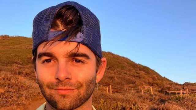 jack griffo in mountains and wearing cap and taking his selfie